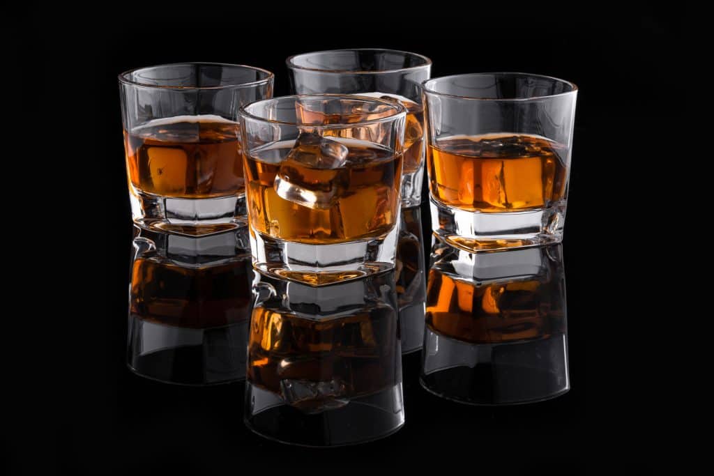4 whiskey glazen op donkere achtergrond